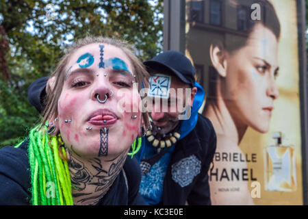 Junge tätowierte Frau Mädchen mit Piercing auf ihrem Gesicht und grünen Dreadlocks, im Rücken ist eine Anzeige auf Parfüm Chanel, Prag, Tschechische Republik Stockfoto