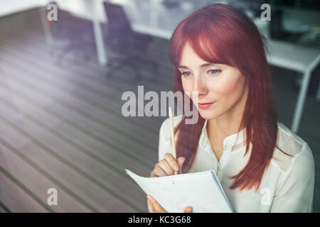 Junge Geschäftsfrau in Ihrem Büro arbeiten. Stockfoto