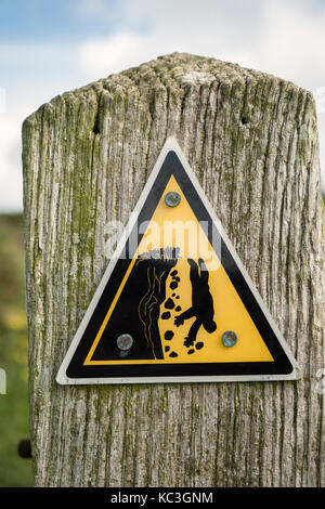 Warnhinweis für eine gefährliche Klippe auf der Pembrokeshire Coastal Path, Wales, UK. Stockfoto