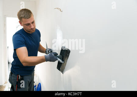 Home Improvement - Bauarbeiter mit verputzen Tools renovieren Wohnung Wände Stockfoto