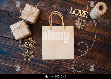 Mockup Papiertüte aus Kraftpapier und Weihnachten Geschenk Boxen auf einer hölzernen Hintergrund Stockfoto