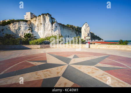 Lungomare (Strandpromenade) von Vieste mit einer Windrose Symbol auf dem Boden und dem Pizzomunno white rock auf Hintergrund konzipiert Stockfoto