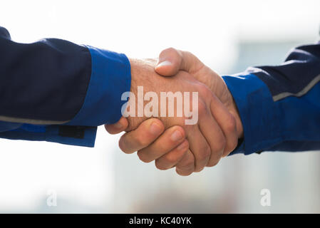 Zugeschnittenes Bild der männlichen Architekten Hände schütteln im Freien Stockfoto