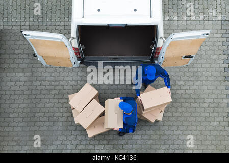 Direkt über dem Schoß der Lieferung Männer entladen Kartons vom Lkw auf der Straße Stockfoto