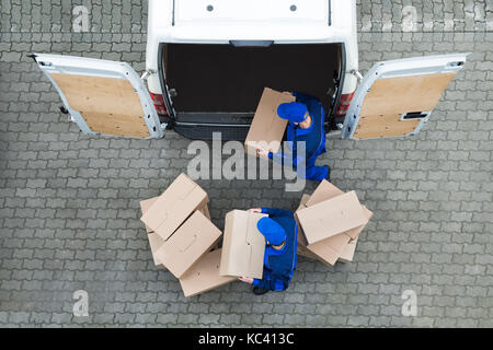 Direkt über dem Schoß der Lieferung Männer entladen Kartons vom Lkw auf der Straße Stockfoto