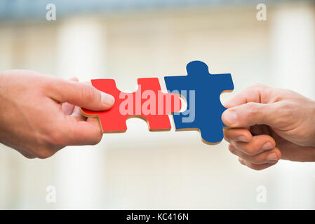 7/8 die Hände von Geschäftsleuten, Jigsaw Pieces im Freien Stockfoto