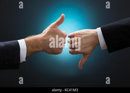 7/8 die Hände von Geschäftsleuten, Vorlieben und Abneigungen Zeichen gegen den blauen Hintergrund Stockfoto