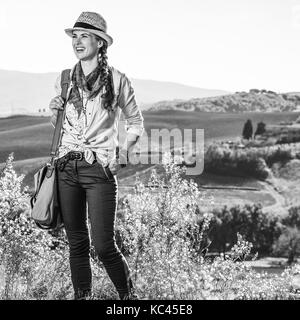 Entdecken Sie magische Ausblicke der Toskana. Glücklich aktive Frau Wanderer mit Beutel genießen Toskana Blick in die Ferne suchen Stockfoto