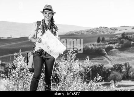 Entdecken Sie magische Ausblicke der Toskana. glückliche gesunde Frau Wanderer mit Tasche wandern in der Toskana mit Karte Stockfoto