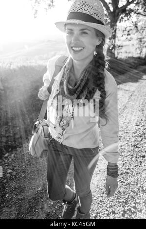 Entdecken Sie magische Ausblicke der Toskana. Glücklich aktive Frau Wanderer in Hut auf der Toskana Wanderung Stockfoto