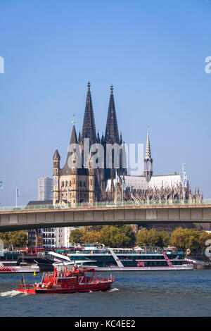 Deutschland, Köln, ein Feuerwehrboot auf dem Rhein vor dem Dom und der Kirche Groß St. Martin. Deutschland, Köln, ein Feuerlo Stockfoto