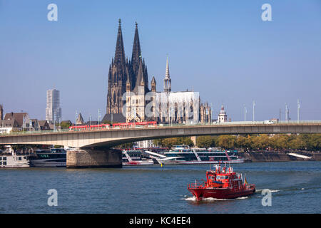 Deutschland, Köln, ein Feuerwehrboot auf dem Rhein vor dem Dom und der Kirche Groß St. Martin. Deutschland, Köln, ein Feuerlo Stockfoto