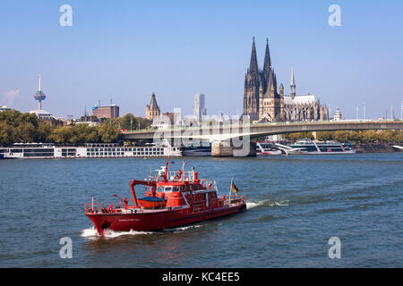 Deutschland, Köln, ein Feuerwehrboot auf dem Rhein, im Hintergrund der Dom und die Kirche Groß St. Martin. Deutschland, Köln, ein Stockfoto