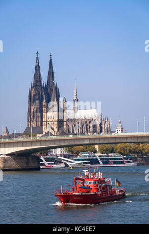 Deutschland, Köln, ein Feuerwehrboot auf dem Rhein vor dem Dom und der Kirche Groß St. Martin. Deutschland, Köln, ein Feuerlo Stockfoto