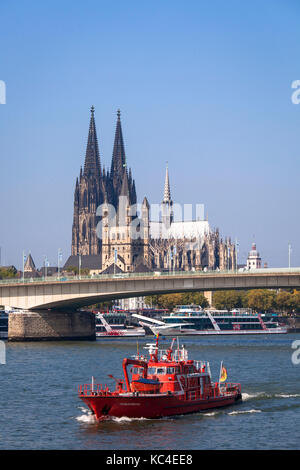 Deutschland, Köln, ein Feuerwehrboot auf dem Rhein vor dem Dom und der Kirche Groß St. Martin. Deutschland, Köln, ein Feuerlo Stockfoto