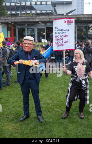 Manchester, Großbritannien. 1. Okt 2017. Eine grosse Demonstration gegen Sparmaßnahmen, die während dem Parteitag der Konservativen Partei in der Innenstadt. Ein Mann in einem Donald Trump Maske hält ein Gummihuhn. Credit: Alex Ramsay/Alamy leben Nachrichten Stockfoto