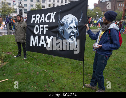 Manchester, Großbritannien. 1. Okt 2017. Eine grosse Demonstration gegen Sparmaßnahmen, die während dem Parteitag der Konservativen Partei in der Innenstadt. Zwei Demonstranten halten ein Banner gegen Fracking, mit einem satanischen Theresa May. Credit: Alex Ramsay/Alamy leben Nachrichten Stockfoto