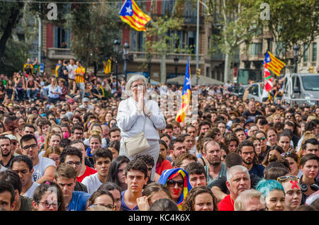 Barcelona, Spanien. 2. Okt 2017. Eine alte Frau gesehen wird durch eine Menge von Studierenden während des Protestes umgeben zu beten. Rund 2000 Schüler versammelt, um gegen die Polizei Ausschreitungen, die am 1. Oktober geschehen zu protestieren, während das Catalonia Referendum. Credit: SOPA Images Limited/Alamy leben Nachrichten Stockfoto