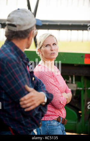 Eine junge weibliche Landwirt Gespräche mit ein mietling vor der überschrift zum Ernten von Weizen auf der Farm der Familie in Breckenridge, Colorado, wo sie wachsen Stockfoto