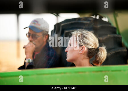 Eine junge weibliche Landwirt Gespräche mit ein mietling vor der überschrift zum Ernten von Weizen auf der Farm der Familie in Breckenridge, Colorado, wo sie wachsen Stockfoto