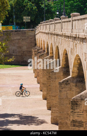 Valencia Turia Garten, ein junger Radfahrer Ansätze die Bögen der Trinidad Brücke im Jardines del Turia Flussbett Park, Valencia, Spanien. Stockfoto