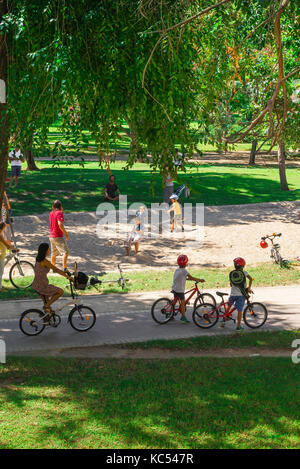 Garten Turia Valencia, eine Familie Radfahren im Turia Flussbett Garten pause Menschen in einen Spielbereich für Kinder, Valencia, Spanien zu beobachten. Stockfoto