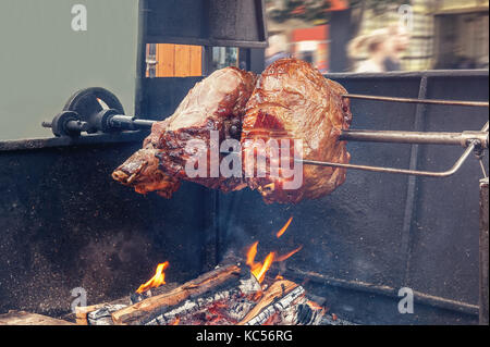 Spieß zum Kochen Braten Schaft in Prag an einem sonnigen Tag. Ein großes Stück Fleisch. Nationale Küche. Der Straße Essen. Stockfoto