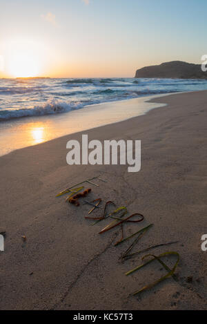 Sonnenuntergang in falassarna mit Beschriftung in Sand aus Algen hergestellt Stockfoto