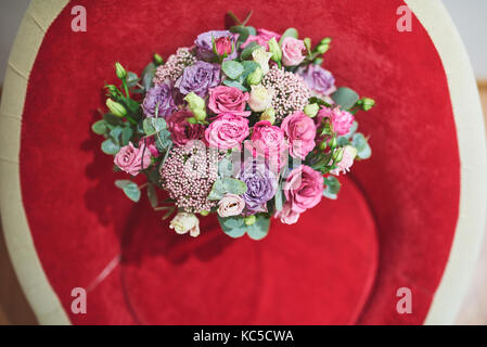 Schönen Brautstrauß mit Seidenbändern und Spitze mit einem Schlüssel in Form von Herzen gebunden. Rosen und Zweige des einen Olivenbaum auf dem alten vintage Hintergrund Stockfoto