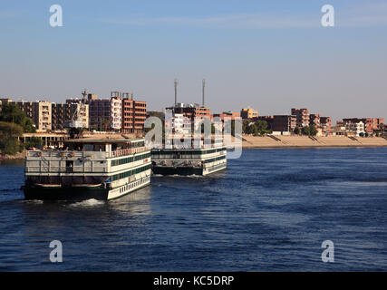 Kreuzfahrtschiffe in der Nähe von Dorf von Kom Ombo auf dem Nil, Ägypten Stockfoto