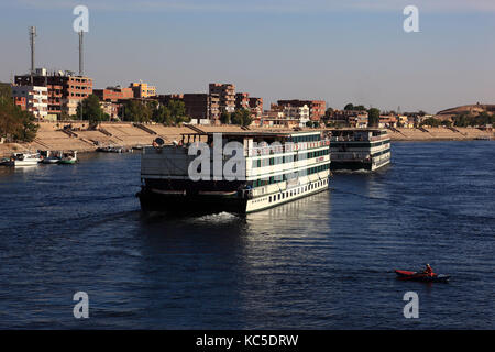 Kreuzfahrtschiffe in der Nähe von Dorf von Kom Ombo auf dem Nil, Ägypten Stockfoto