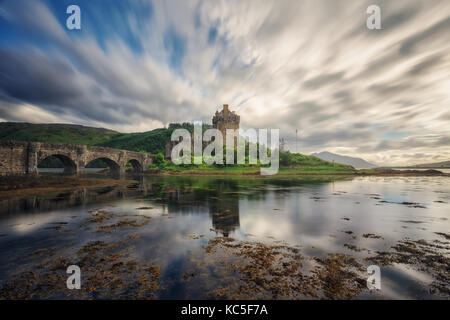 Eilean Donan Castle auf einem Tageslicht Fotos mit langer Belichtungszeit. Highlands Lochs. Wolken Bewegung. Bogenbrücke. Reflexion Stockfoto