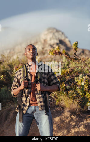 Junge afrikanische Mann heraus für eine Wanderung in der Wüste Stockfoto