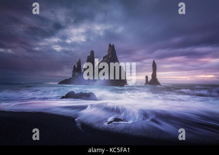 Bewölkt Abend am Strand Reynisfjara in Island. Das berühmte Sea Stacks und die Wellen an den Strand. Moody Wetter. Stockfoto