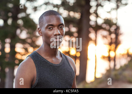 Afrikanischer Mann stehend auf einem Trail beim Joggen konzentriert Stockfoto