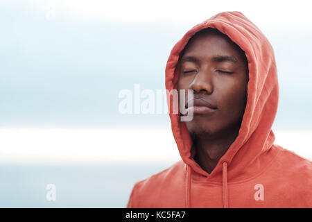 Junge afrikanische Mann, bevor sie sich für einen Lauf konzentriert Stockfoto