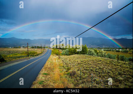 Regenbogen über CR 120 & der kleinen Bergstadt Salida, Colorado, USA Stockfoto