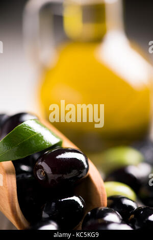 Frische schwarze Oliven auf einen Olivenzweig mit Blättern Stockfoto