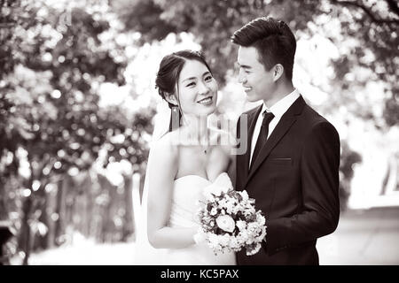 Outdoor Portrait von asiatische Braut und Bräutigam, glücklich und lächelnd, Schwarz und Weiß. Stockfoto