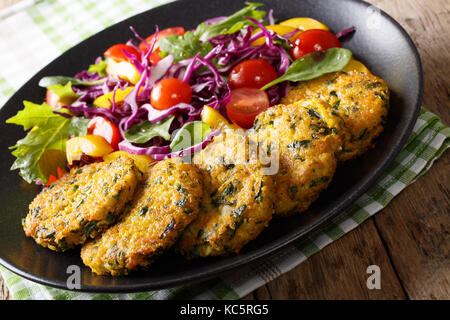 Diätetische Krapfen von Quinoa, Karotten und Spinat und Salat close-up auf einem Teller. Horizontale Stockfoto