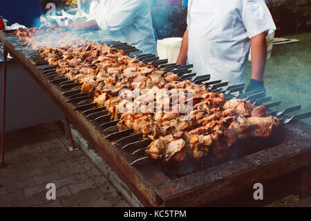 Gegrilltes kebab Kochen auf Metall Spieße Grill gebratenes Fleisch am Grill mit Rauch gekocht. Nahaufnahme bbq frisches Schweinefleisch Schnitte hacken. traditionellen easte Stockfoto