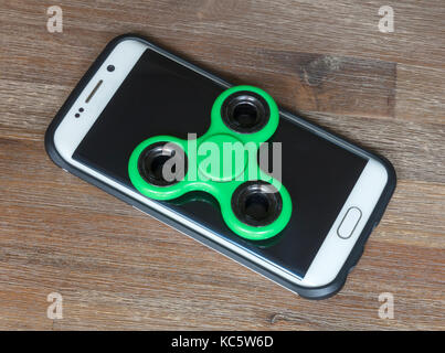 Kinder Spielzeug;Smartphone mit einem grünen Spinner auf der Oberseite Stockfoto