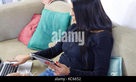 Hübsche junge Frau zu Hause, mit Tablet-PC Stockfoto