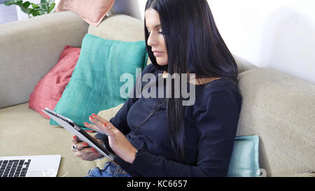 Hübsche junge Frau zu Hause, mit Tablet-PC Stockfoto