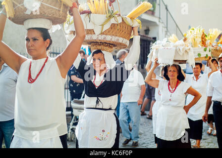 Typische italienische Folklore reife Frauen feiern Jungfrau Maria August Urlaub, indem Sie Getreide und Blumenkörben auf ihre Köpfe. Santo Stefano. Cammi Stockfoto