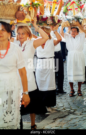 Typische italienische Folklore reife Frauen feiern Jungfrau Maria August Urlaub, indem Sie Getreide und Blumenkörben auf ihre Köpfe. Santo Stefano. Cammi Stockfoto