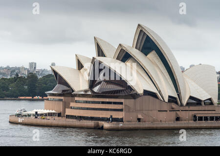 Sydney, Australien - 21. März 2017: Nahaufnahme von Oper unter grauen regnerischen Himmel. Wasser vor, die Menschen auf den Plattformen. Stockfoto