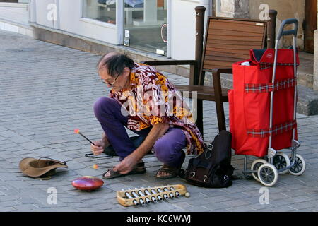 Straßenmusiker oder Gaukler spielen eine Zunge Trommel oder Hank Drum Stockfoto