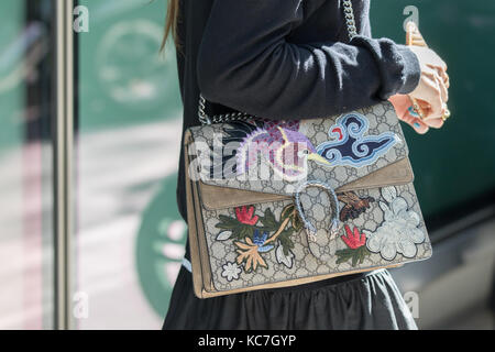 Mailand, Italien - 22. September 2017: Modell trägt eine Schultertasche mit Blumenschmuck und schwarzen Kleid während der armani Parade, fotografiert auf der Stockfoto