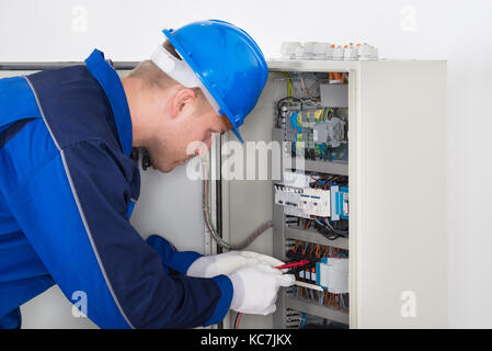 Männliche Techniker Prüfung Sicherungskasten mit digitalen Isolationswiderstand Tester Stockfoto